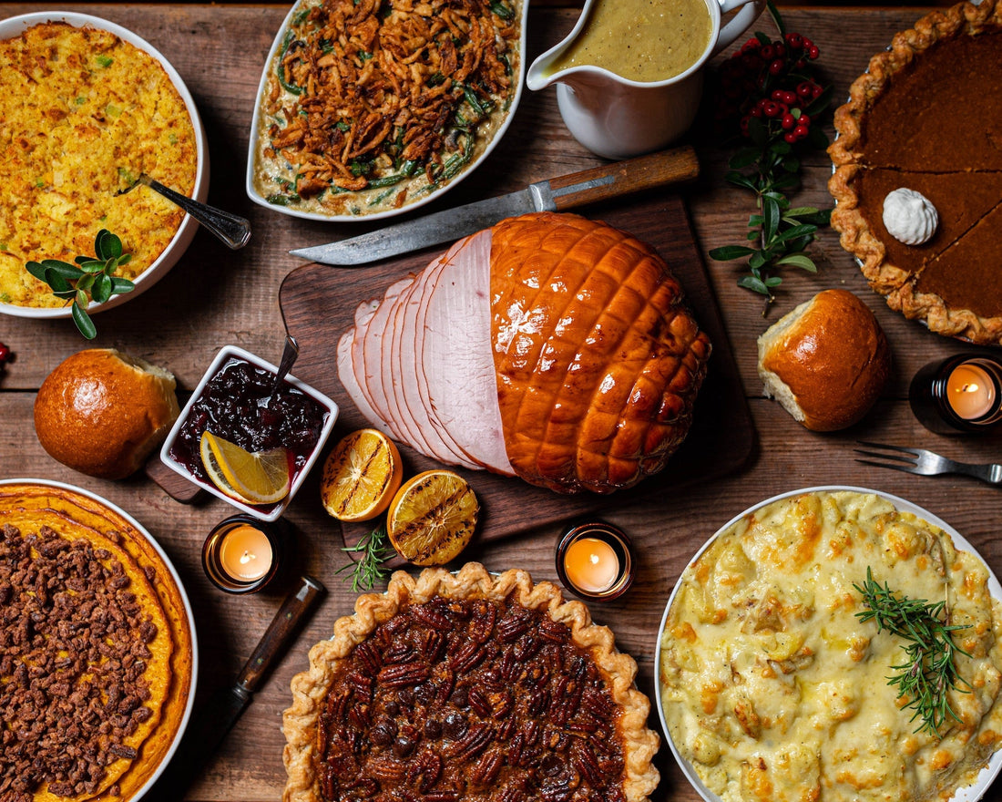 thanksgiving dinner table with pie, mashed potatoes, and ham.